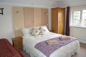 a bedroom with a bed with two towels on it at Sunnycroft in Sutton on Sea