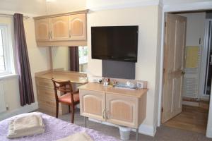 a room with a desk with a tv and a bed at Sunnycroft in Sutton on Sea +12 photos