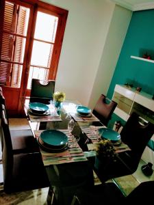a dining room with a table with plates and glasses at Turquesa de Sevilla Suite in Seville