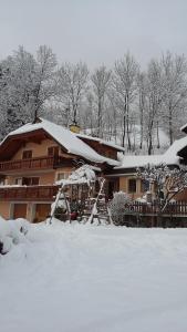 ein schneebedecktes Haus mit einem schneebedeckten Hof in der Unterkunft Müllnerhaus in Millstatt