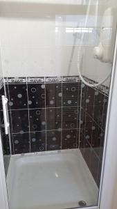 eine Dusche mit einer schwarz-weißen Wand in der Unterkunft Sunnycroft in Sutton on Sea