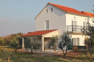een groot wit huis met een oranje dak bij Holiday Home Hrast in Debeljak