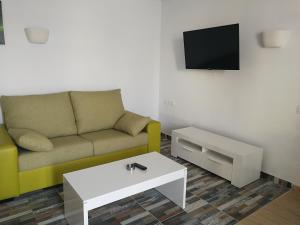 
a living room filled with furniture and a tv at Huella Canaria in Playa del Ingles
