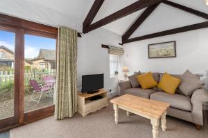a living room with a couch and a tv at Mill Cottage in Paignton