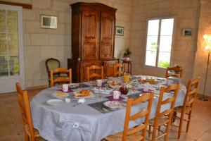 ein Esszimmer mit einem Tisch mit Essen drauf in der Unterkunft LES CHAMBRES D HOTES DU LAVOIR in Restigné