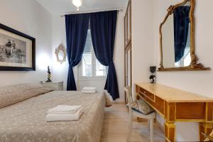 a bedroom with a bed and a desk and a mirror at Faenza Apartment in Florence