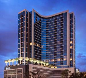 休斯顿Hanover Post Oak的一栋高楼，前面种着棕榈树。