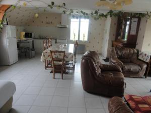 cocina y sala de estar con mesa y sillas en Gîte les blés dorés à 7 km de DERVAL., en Conquereuil