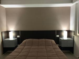 une chambre avec un grand lit avec deux tables de nuit dans l'établissement Il Parco Di Yuki (2), à Ancône