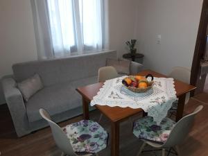 a living room with a table with a bowl of fruit on it at Dimitra's Garden Villa in Kallirákhi