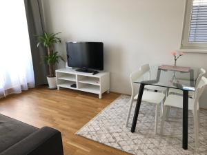 salon z telewizorem, stołem i krzesłami w obiekcie High 5 w Grazu