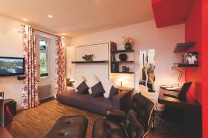 a living room with a couch and a desk at Studio La Savoyarde - Vision Luxe in Menthon-Saint-Bernard