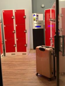 a suitcase sitting in a room with red lockers at Wonderful Apartment Budapest in Budapest