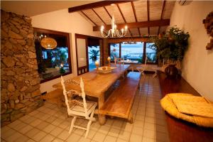 uma sala de jantar com uma mesa de madeira e cadeiras em Pousada Casa do Bicho Preguiça em Angra dos Reis