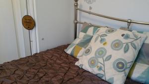 uma cama com duas almofadas com um relógio em cosy annex close to leeds airport em Guiseley