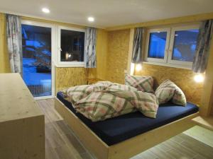 a bed in a room with windows in a room at Haus Mittagspitze in Mellau