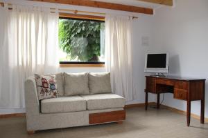 Aysén Cabañas في بويرتو آيسن: غرفة معيشة مع أريكة ومكتب مع تلفزيون