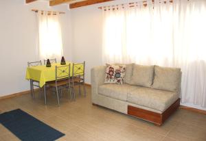 Aysén Cabañas في بويرتو آيسن: غرفة معيشة مع أريكة وطاولة
