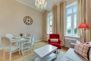 a living room with a table and a red chair at BE IN GDANSK Apartments - IN THE HEART OF THE OLD TOWN - Ogarna 10 in Gdańsk