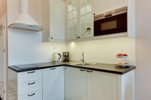 a kitchen with white cabinets and a sink at BE IN GDANSK Apartments - IN THE HEART OF THE OLD TOWN - Ogarna 10 in Gdańsk