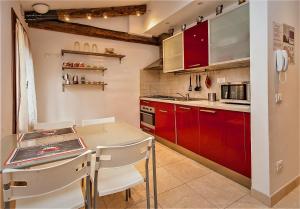 a kitchen with red cabinets and a table and chairs at Ca Rossa - Venezia in Venice