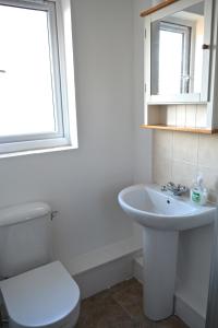 a white bathroom with a toilet and a sink at Apartment in Central London Zone 2 in London