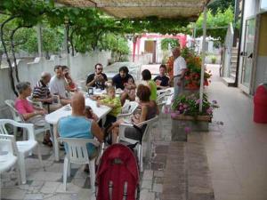 a group of people sitting at an outdoor restaurant at Aquamarine Residence in Davoli