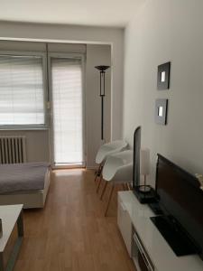 a living room with a bed and a flat screen tv at ARSS Apartment Skopje Main Square in Skopje