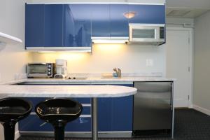 a kitchen with blue cabinets and two black stools at Stylish Newbury Street Studio, #4 in Boston +16 photos