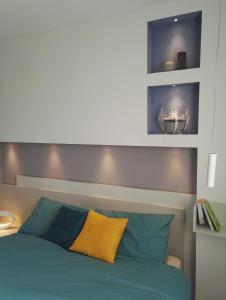 a bedroom with a bed with blue and yellow pillows at Casa Lu in Levico Terme