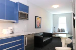 a kitchen with blue cabinets and a living room at Comfortable Studio in Back Bay, Newbury St. #7 in Boston