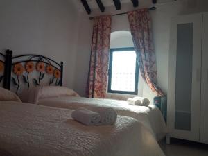 a bedroom with two beds and a mirror and a window at Apartamento Sierra de Grazalema in Prado del Rey