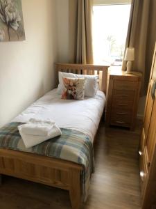 Una pequeña cama con un gato sentado encima. en 12 Lochiel Road, en Fort William