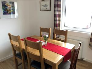una mesa de comedor con un mantel rojo. en 12 Lochiel Road, en Fort William