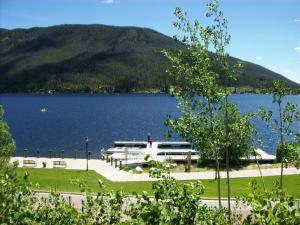 a boat on a lake with a mountain in the background at Western Riviera Lakeside Lodging in Grand Lake