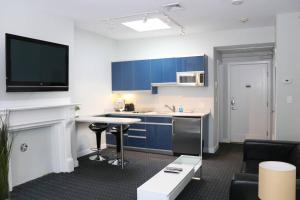 a kitchen with blue cabinets and a living room at Stylish Studio on Newbury St, THIS IS BOSTON! #12 in Boston