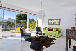 a living room with a green couch and a table at Villas Sol e Poesia in Albufeira