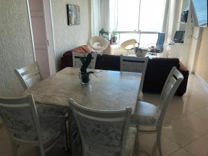 a dining room table and chairs in a living room at Baln Camboriu - Beira mar in Balneário Camboriú