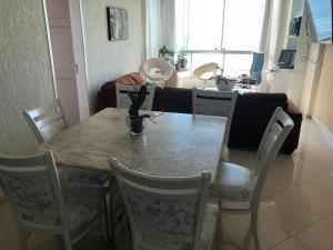 uma mesa de jantar e cadeiras numa sala de estar em Baln Camboriu - Beira mar em Balneário Camboriú