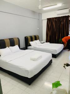 a room with two beds and a window at Town City Home sweet home in Kuala Terengganu