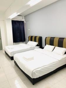 a room with three beds in a room at Town City Home sweet home in Kuala Terengganu