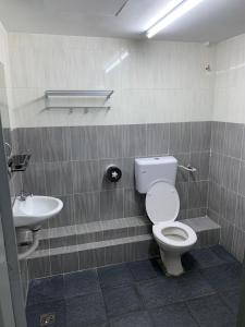 a bathroom with a toilet and a sink at Town City Home sweet home in Kuala Terengganu +1 photo