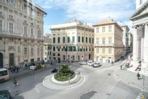 a city street with buildings and a tree in the middle at Nunziata Apartment in Genova