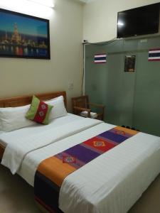 a hotel room with two beds and a flat screen tv at Chau A Hotel in Hải Dương