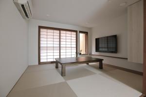 a living room with a table and a tv at 京都 六花庵 Kyoto Rokkaan in Kyoto