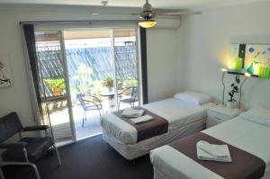 a hotel room with two beds and a balcony at Isla House Greenslopes in Brisbane