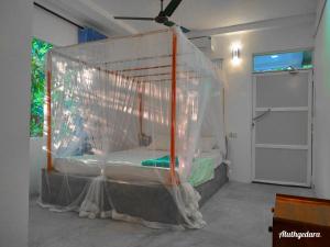 a bedroom with a bed covered in netting at Aluthgedara Guest House in Unawatuna