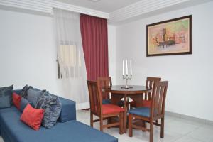 a living room with a blue couch and a table at Residence Maryka II in Cotonou