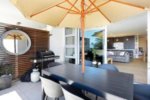 comedor con mesa y sombrilla en Sea Path Apartment, en Nelson