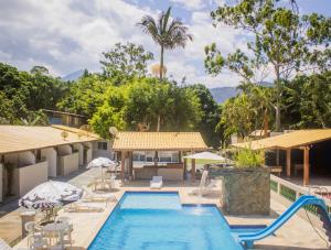 a swimming pool with a resort with a resort at Pousada Litoreza - Natureza e conforto em perfeita sintonia in Peruíbe